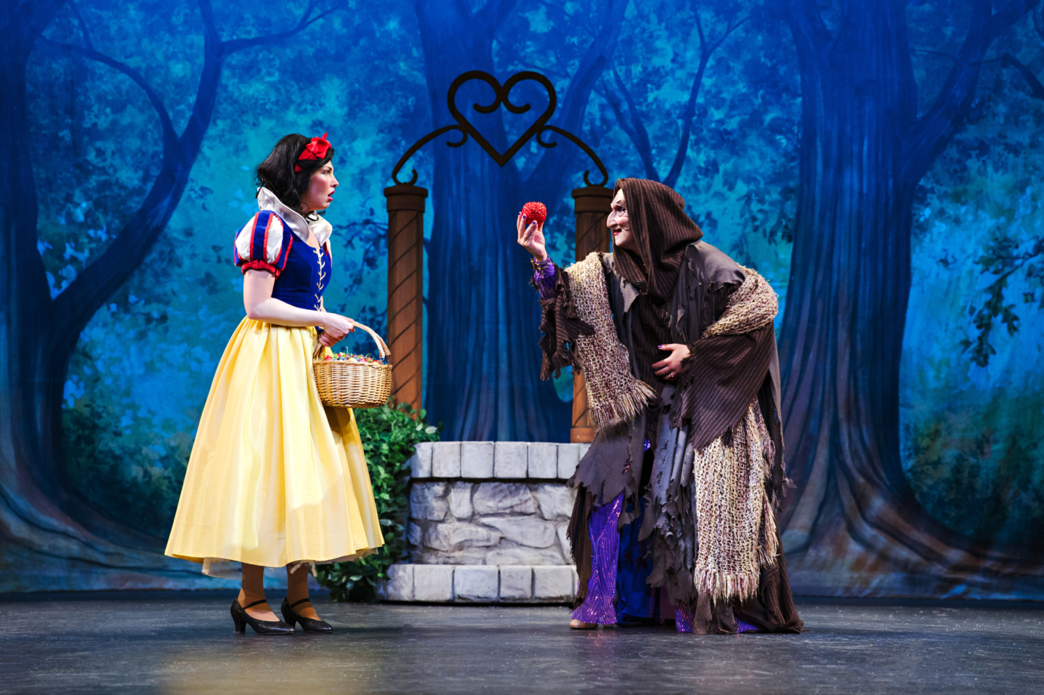 Snow White and the Seven Tenors title inside a gold mirror frame with stage lights, stars, and clouds on a blue background.