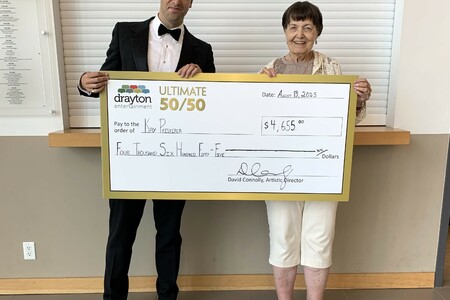 The Crooner actor Michael Vanhevel presents a giant cheque to Kay Pfisterer, the winner of Drayton Entertainment’s Ultimate 50/50 Draw. The cheque is made out for $4,655.<
