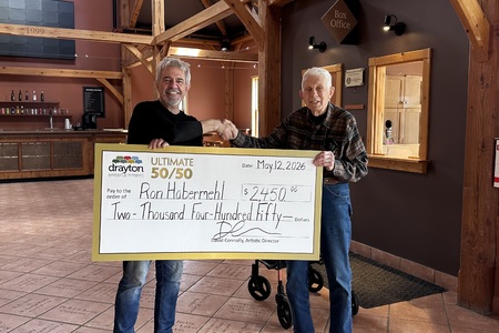 Alex Mustakas presents a giant cheque to Ron Habermehl, the winner of Drayton Entertainment’s Ultimate 50/50 Draw. The cheque is made out for $2,450.
