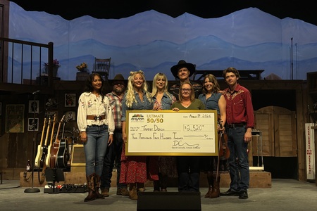 Actors Brianna Clark, Leah Grandmont, Kristen Peace, Roman Pfob, Jack Ryckman, Laura Tremblay, and Aaron Walpole present a cheque for $2,520 to Tammy Dixon at the Hamilton Family Theatre.