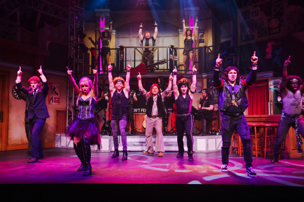 Production photo of Rock of Ages, showing the entire company dancing with dramatic lighting. 