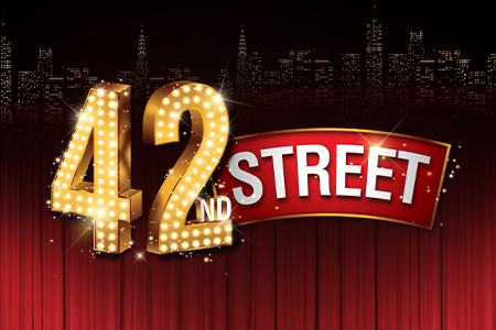 42nd Street appears in bold silver letters against a dark blue starry background, illuminated by a soft spotlight that creates a theatrical, Broadway-inspired atmosphere.